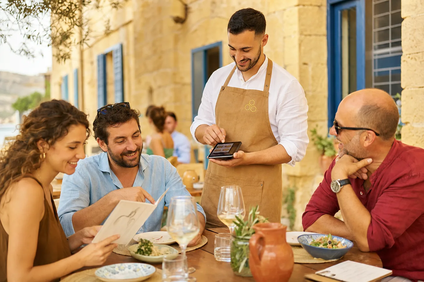 A waiter takes the order at the table on a handheld